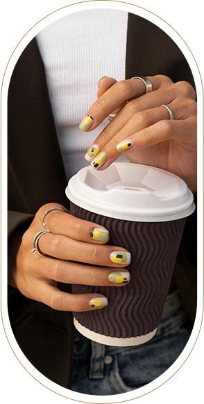 woman showing her nail art fingernails with coffee cup